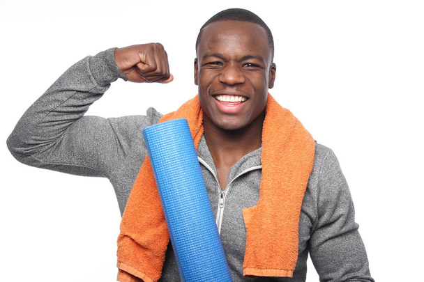 Black sportsman with towel and yoga carpet - Foto, afbeelding