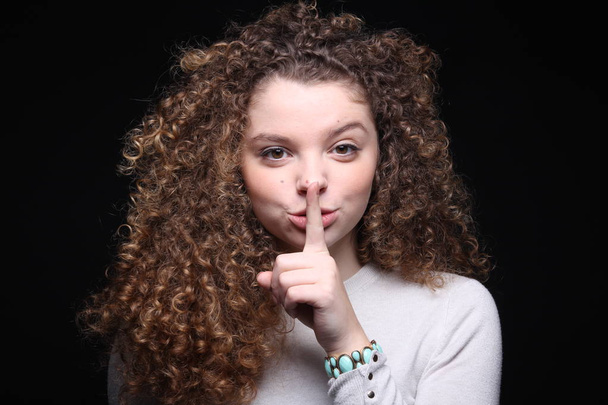 Beautiful caucasian girl is showing silence sign - Foto, Imagen