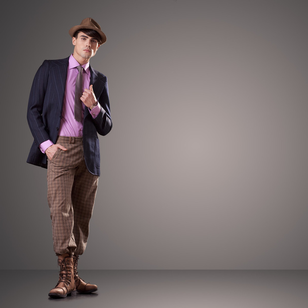 atraktivní mladý mužský model dresed v oblečení izolovaných na šedé backgroung - Fotografie, Obrázek