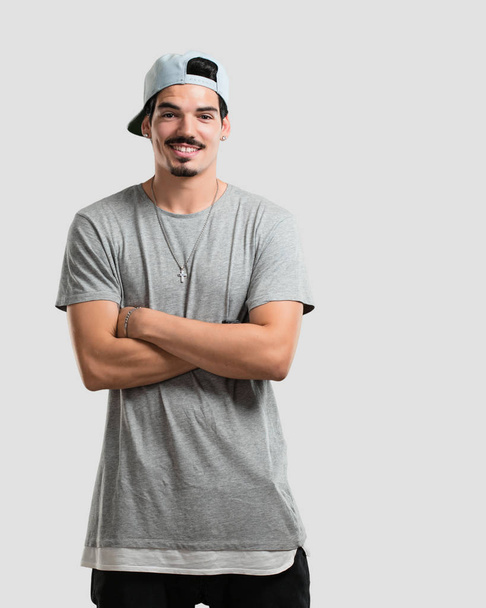 Young rapper man crossing his arms, smiling and happy, being confident and friendly - Foto, afbeelding