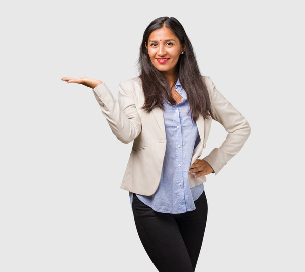 Joven mujer india de negocios sosteniendo algo con la mano
 - Foto, imagen