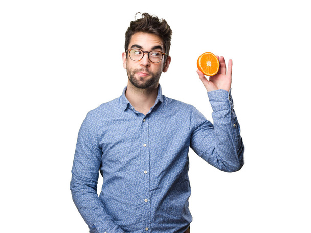 młody człowiek trzyma na białym tle pomarańczowy - Zdjęcie, obraz