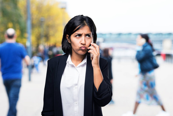 Латиноамериканская деловая женщина разговаривает по мобильному телефону
 - Фото, изображение