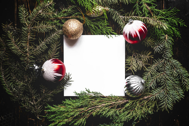 επίπεδη κορυφή Βάλτε διάταξη των Χριστουγέννων διακόσμηση παιχνίδια με κενό λευκό πλαίσιο στο πεύκο δέντρο κλαδιά έννοια s - Φωτογραφία, εικόνα