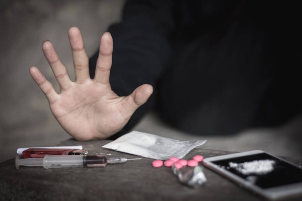  Людські руки на темному фоні, поняття "Припини наркоманію", "Не втручайся в наркотики", "Міжнародний день проти зловживання наркотиками". - Фото, зображення