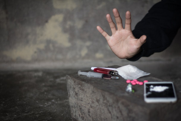  Людські руки на темному фоні, поняття "Припини наркоманію", "Не втручайся в наркотики", "Міжнародний день проти зловживання наркотиками". - Фото, зображення