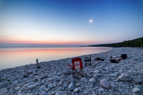岩のビーチでオンタリオ州、カナダの空を撮影する友人との夜を過ごした後の朝早く - 写真・画像