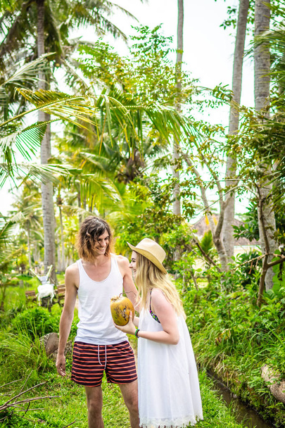 Νέος μήνας του μέλιτος ζευγάρι βαδίζει ανάμεσα στους ορυζώνες. Όμορφο ταξίδι των newleds στο νησί του Μπαλί, Ινδονησία. Φύση, καλοκαίρι, πράσινο, φωτεινό. - Φωτογραφία, εικόνα