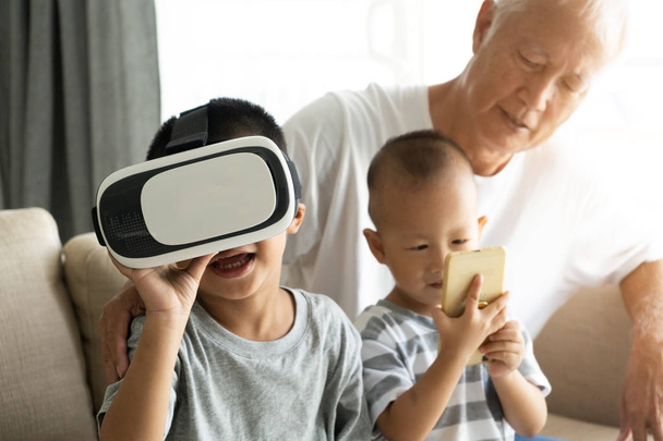asian boy using VR goggles with grandparent technology photo - Fotoğraf, Görsel