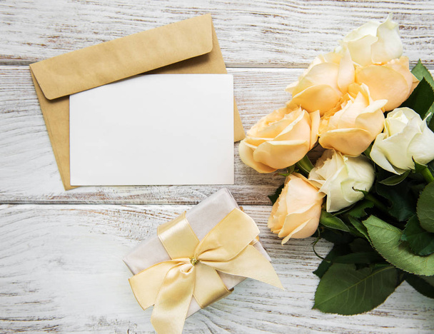 Roses blanches et carte de vœux sur une vieille table en bois
 - Photo, image