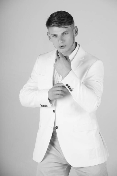 Model posing in white jacket, striped shirt and blue pants - 写真・画像