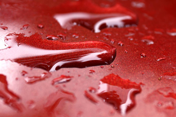 kapičky vody mokré na červené auto povrchu hood, kapka vody na červené texturou, vodu přesuňte mokré close-up (Selektivní ostření) - Fotografie, Obrázek