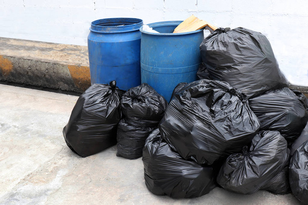 σκουπίδια είναι σωρός πολλά χωματερή, πολλές πλαστικές σακούλες μαύρες αποβλήτων στο χωριό κοινότητα διάβαση πεζών, ρύπανση από Απορρίμματα πλαστικών αποβλήτων σκουπίδια, τσάντες Μπιν των πλαστικών αποβλήτων, αποβλήτων σωρό σκουπίδια, πολλά σκουπίδια σκουπιδότοπος - Φωτογραφία, εικόνα