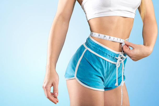 cropped image of slim young woman with a tape measure - Φωτογραφία, εικόνα