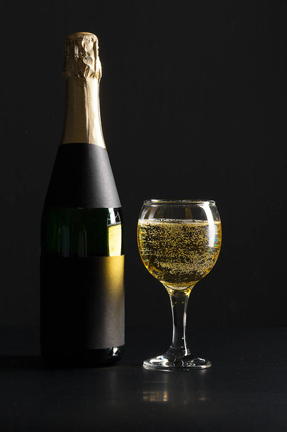 champagne wine glass and bottle on black background - Фото, изображение