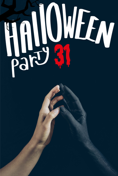 cropped view of woman touching with black demon hand isolated on black with "halloween party 31" lettering - Photo, Image