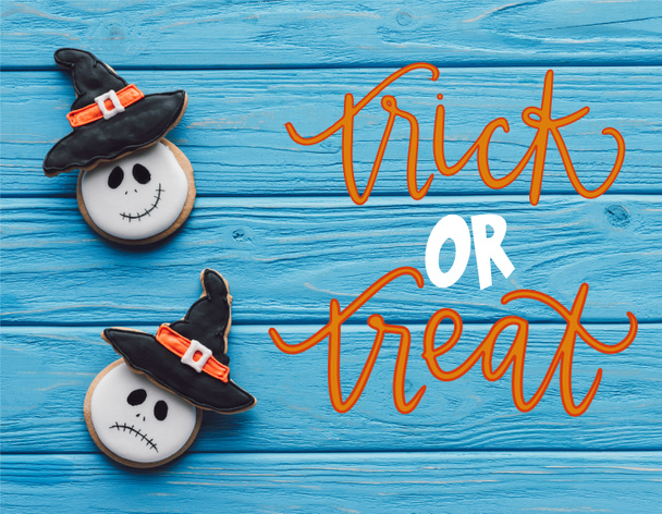 Blick auf köstliche hausgemachte Halloween-Plätzchen auf Holzgrund mit "Trick or treat" -Schriftzug - Foto, Bild