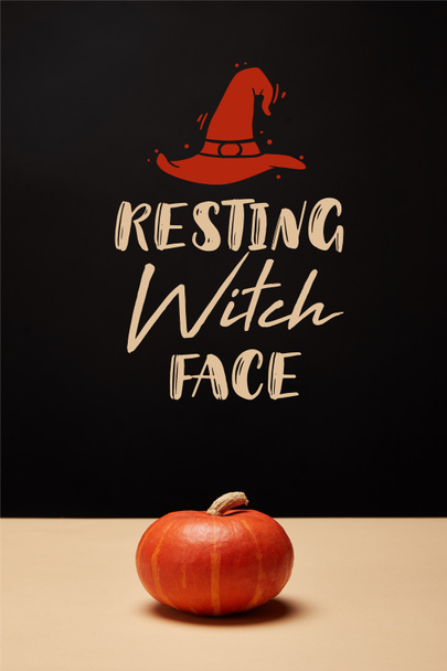una calabaza naranja en la mesa con sombrero de bruja y letras de "cara de bruja en reposo"
 - Foto, Imagen