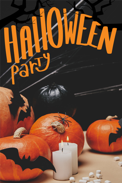 тыквы с бумажными летучими мышами и паутиной на столе с надписью "Halloween party"
 - Фото, изображение