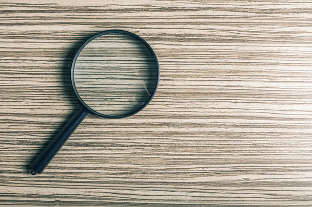 magnifying glass on wooden background, close-up  - Photo, image