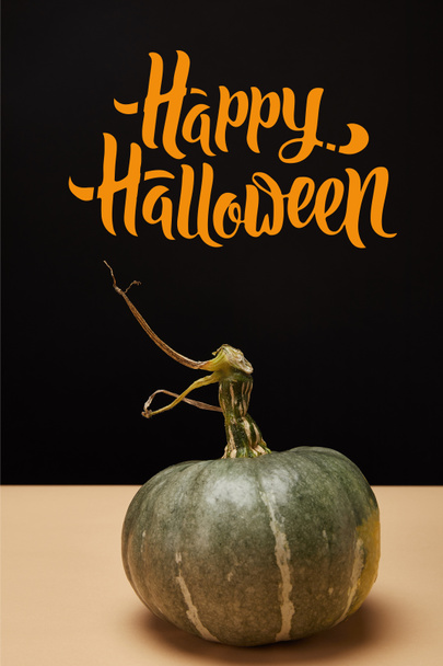 one green pumpkin on table with "happy halloween" lettering   - Foto, Imagem