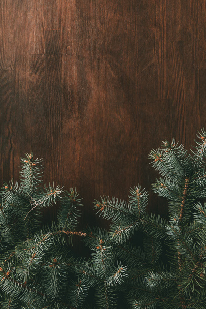 green fir branches on brown wooden background - Valokuva, kuva