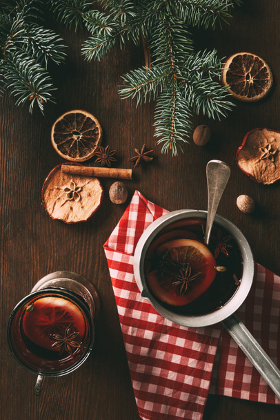 a hagyományos karácsonyi felülnézet forralt bor a fűszerek, a fenyő ágak fából készült háttér - Fotó, kép