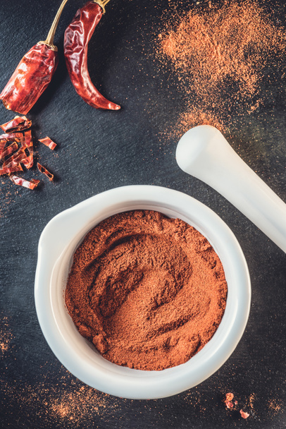top view of aromatic chili powder and red hot chili peppers on black - Valokuva, kuva