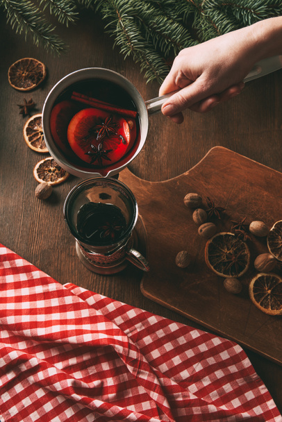 partial view of person pouring hot spiced wine into glass - Foto, imagen