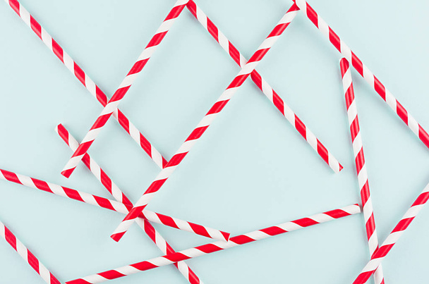 Playful trendy colors abstract background - red striped straws as pattern on mint paper backdrop.  - Φωτογραφία, εικόνα