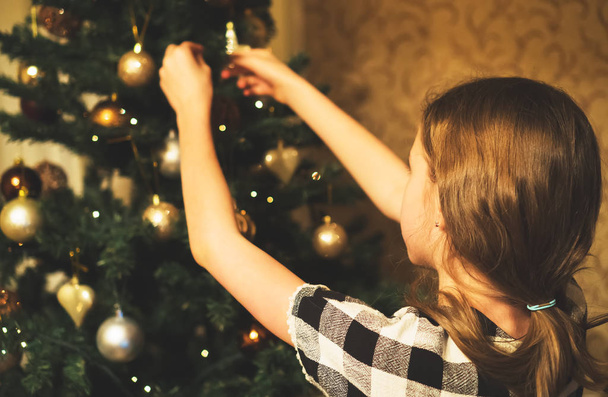Little girl decorates the Christmas tree - Фото, изображение