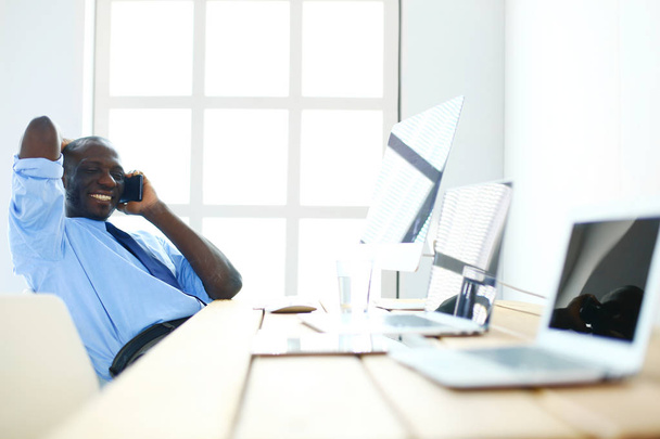 African american businessman on headset working on his laptop - Foto, imagen