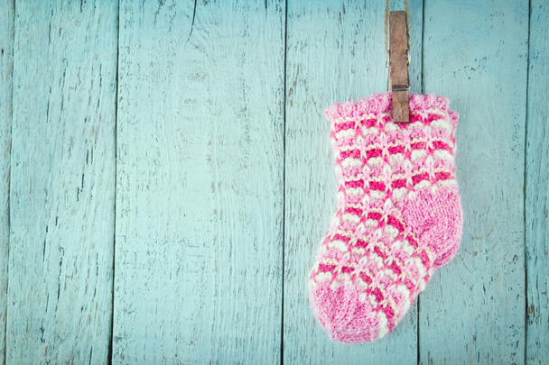 Pink baby sokken op een blauwe achtergrond van houten - Foto, afbeelding