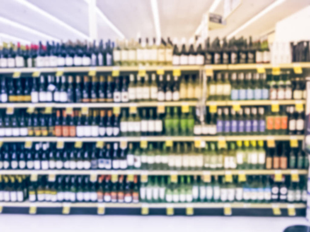Vin abstrait flou allée avec des étiquettes de prix à l'épicerie au Texas, en Amérique. Des rangées déconcentrées de bouteilles de vin rouge et blanc sur les étagères des supermarchés. concept de boisson alcoolisée fond
 - Photo, image
