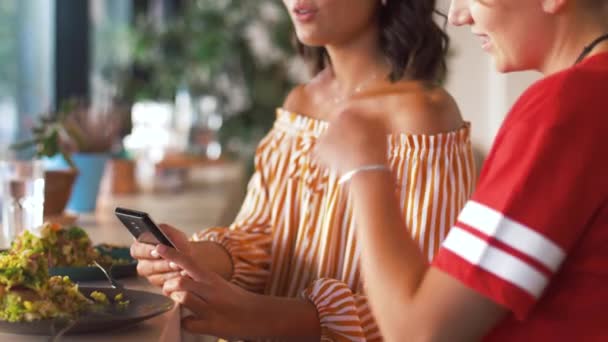 female friends with smartphone at restaurant - Metraje, vídeo