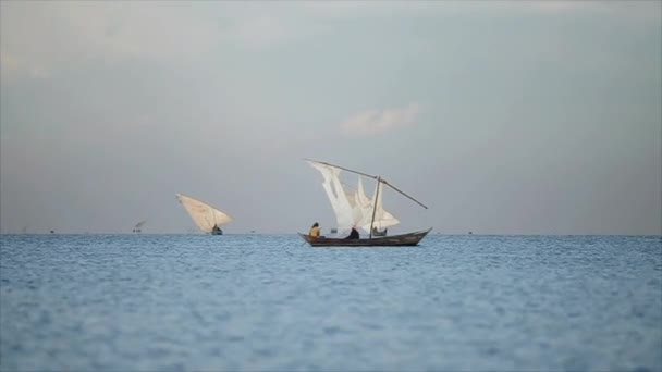 Mooi landschap van zee en vissers. Afrikaanse mannen werken in de Oceaan op zeilboten, lokale bedrijfsadvertenties. - Video