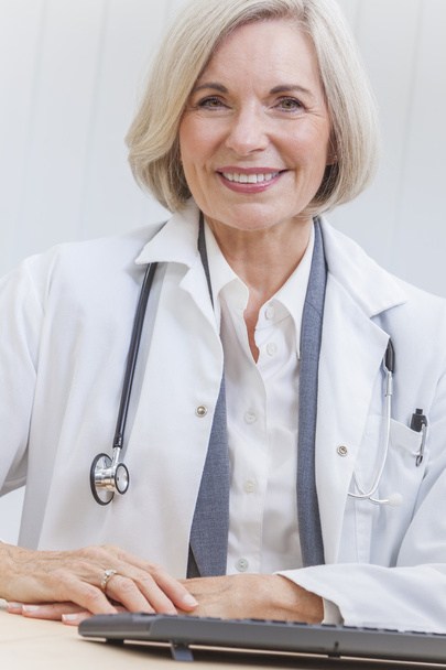 Senior Female Doctor With Stethoscope at Desk & Computer - Foto, Imagem