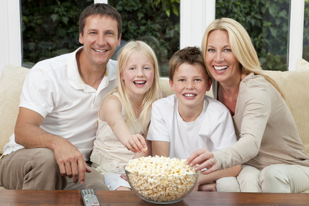ευτυχισμένη οικογένεια τρώγοντας ποπ κορν βλέποντας τηλεόραση - Φωτογραφία, εικόνα