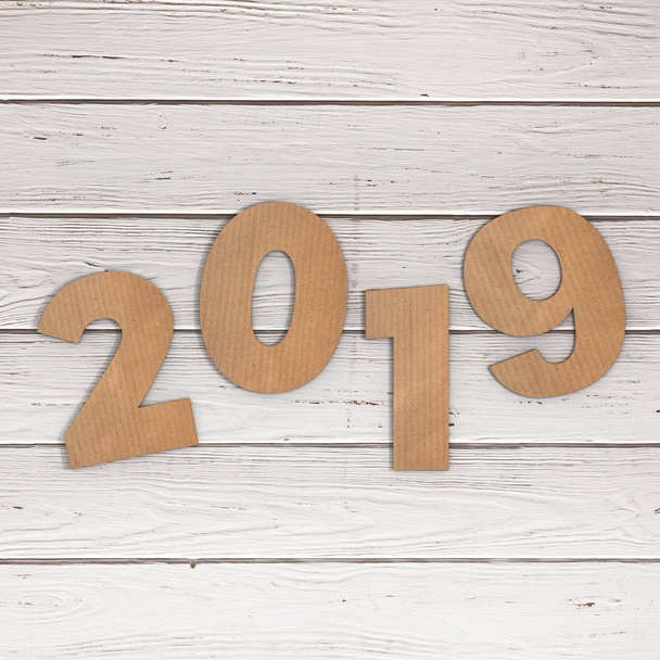 Cardstock Numbers 2019 Happy New Year Sign over wooden table background. 3d Rendering - Photo, Image