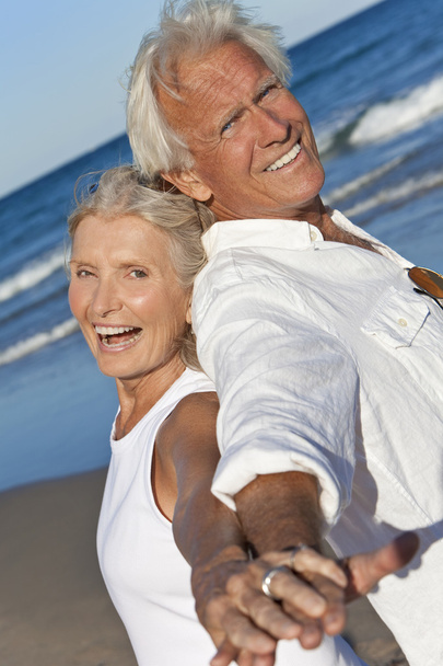 szczęśliwa para starszy powrotem do tyłu trzymając się za ręce na plaży - Zdjęcie, obraz