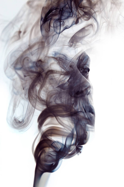 Black and white, unique conceptual work bringing together the unpredictable nature of smoke with the firm gaze of a young man - 写真・画像