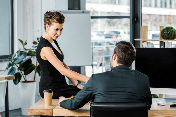 jonge zakenvrouw flirten met collega op werkplek op kantoor - Foto, afbeelding