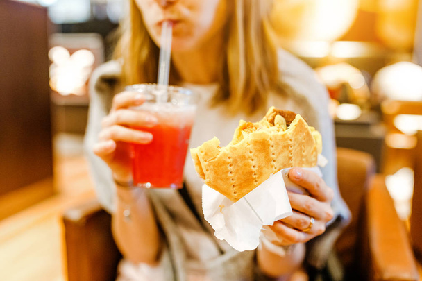Женщина ест сэндвич с пита в кафе
 - Фото, изображение