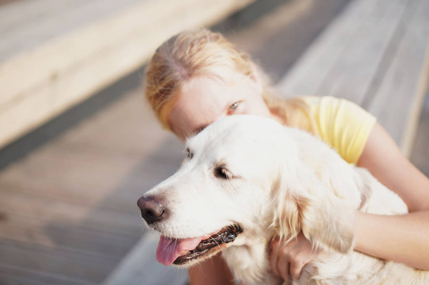 αγάπη για τα ζώα συντροφιάς - μια νεαρή ξανθιά γυναίκα ανάπαυσης με το σκύλο της στο δρόμο - Φωτογραφία, εικόνα