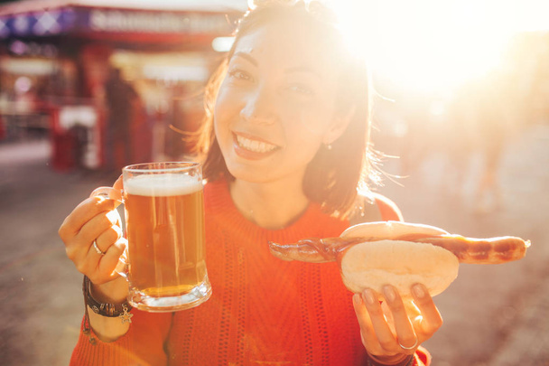 Jeune voyageur asiatique heureux femme boit tasse de bière avec hotdog en Allemagne, concept de festival de bière et de nourriture
 - Photo, image