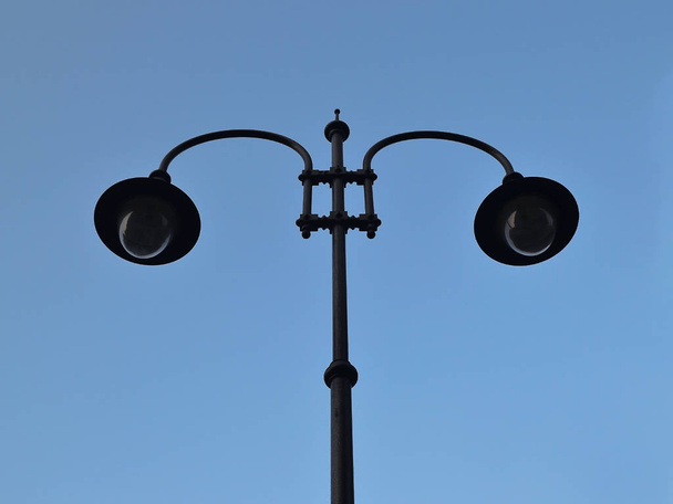 Street lamp with two lights against a blue sky, bottom view - Zdjęcie, obraz