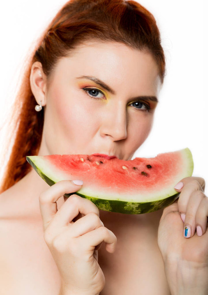 Beautiful nude redhead woman eating a slice of watermelon. concept of healthy eating - Foto, immagini