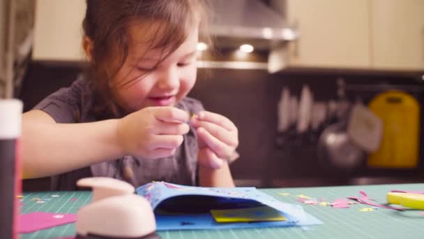 Pieni tyttö liimaamalla värillinen paperi
 - Materiaali, video