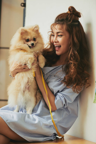 Young asian woman playing with little dog - Foto, immagini