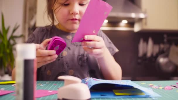 Pieni tyttö leikkaa lintuja värillisestä paperista
 - Materiaali, video